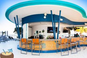 a bar at a resort with orange chairs at Wyndham Ocean Walk Resort - Vacation in Comfort by the sea - 2BR Oceanview 24320 in Daytona Beach +44 photos