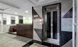 un hall avec un ascenseur en verre dans un immeuble dans l'établissement Treebo Trend Excella, à Visakhapatnam