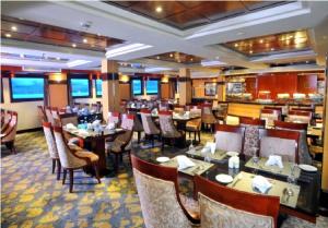 live Nile in style Nile cruise in Luxor and Aswan في الأقصر: غرفة طعام مع طاولات وكراسي في مطعم