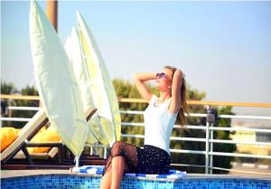 Eine Frau, die am Pool sitzt in der Unterkunft live Nile in style Nile cruise in Luxor and Aswan in Luxor
