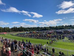 a large crowd of people watching a horse race at Overleigh Cottage, with optional Hot Tub hire in Chester