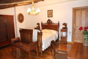 CASA RURAL SANCHO في Artajona: غرفة نوم بسرير وطاولة وكراسي