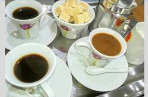 three cups of coffee on a table with cookies at Urban Hostel in Peje