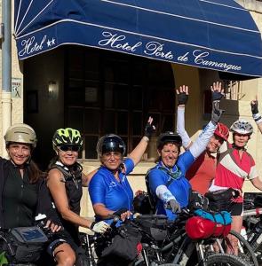 un groupe de personnes à vélo devant un bâtiment dans l'établissement Hôtel Porte de Camargue - Les Quais d'Arles, à Arles
