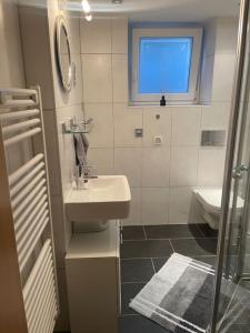 uma casa de banho com um lavatório, um WC e uma janela. em Flughafennahe 100 qm Oase mit eigenem Fitnessraum em Holzwickede