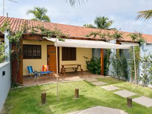 a patio with a table and a white umbrella at Casinhas Terõ - in São Sebastião