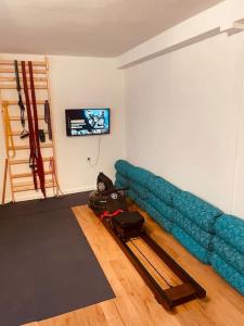 uma sala de estar com um sofá azul e uma televisão em Flughafennahe 100 qm Oase mit eigenem Fitnessraum em Holzwickede