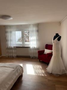 ein Hochzeitskleid hängt an einer Wand in einem Schlafzimmer in der Unterkunft Flughafennahe 100 qm Oase mit eigenem Fitnessraum in Holzwickede