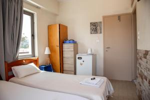 a hotel room with two beds and a window at Nefeli Rooms in Agia Marina Nea Kydonias