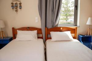 dwa łóżka siedzące obok siebie w sypialni w obiekcie Nefeli Rooms w mieście Agia Marina Nea Kydonias
