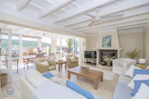 Elle comprend un salon doté d'un mobilier blanc et d'une cheminée. dans l'établissement Lovely family villa sleeps 8, with stunning views, à Port Mahon