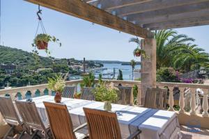 una mesa en un balcón con vistas al agua en Lovely family villa sleeps 8, with stunning views en Mahón