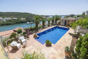 una piscina con palmeras y un río en Lovely family villa sleeps 8, with stunning views en Mahón
