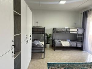 um quarto com 2 beliches e uma porta em Hostel by Fenix Tirana em Tirana