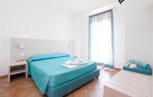 ein Schlafzimmer mit einem blauen Bett und einem Fenster in der Unterkunft Beach Front Home In Marina Di Modica in Marina di Modica