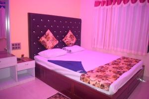 um quarto com uma cama grande e iluminação rosa em THE ROYAL BEACH HOTEL AND RESORT em Mandarmoni