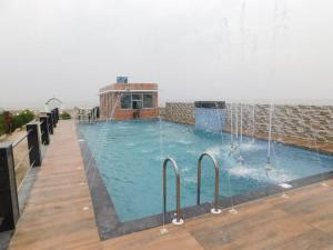 uma grande piscina com uma fonte de água em THE ROYAL BEACH HOTEL AND RESORT em Mandarmoni