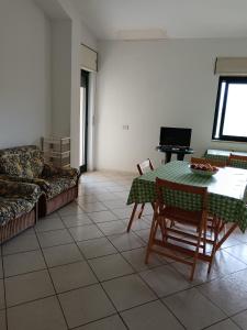ein Wohnzimmer mit einem Tisch und einem Sofa in der Unterkunft Casa Annamaria in Torre Orsaia
