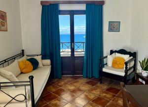 a living room with a bed and a window with blue curtains at SYROU LOTOS Studios & Apartments in Kini
