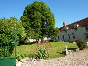 un patio con una casa y un árbol en Maison dans belle longère - La Serrerie en Thenay