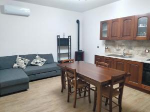eine Küche und ein Wohnzimmer mit einem Tisch und einem Sofa in der Unterkunft Casa Baglio Viole in Valderice