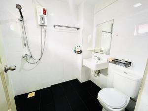 a white bathroom with a toilet and a sink at Convenient Rare house in central city in Singapore