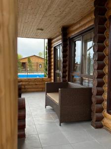 a living room with a couch and windows at Soho Hutor in Bosteri