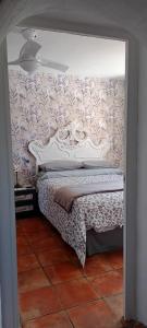een slaapkamer met een bed met een muur bedekt met bloemen bij La Estrellita in Iznájar