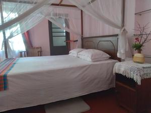 a bedroom with a large white bed with a window at Sujatha Villa Paradise in Tangalle