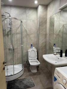 a bathroom with a shower and a toilet and a sink at Chavchavdze VAKE - 1BR Apartment in Tbilisi City