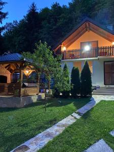 ein Haus mit einem Balkon und einem Garten in der Nacht in der Unterkunft Forest House Bosnia in Busovača