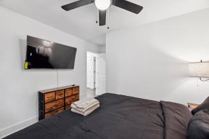 Schlafzimmer mit einem Bett und einem Flachbild-TV in der Unterkunft Coastal Retreat Oasis- Perfect for large groups in Atlanta