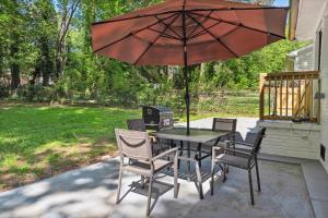einen Tisch und Stühle mit Sonnenschirm auf einer Terrasse in der Unterkunft Coastal Retreat Oasis- Perfect for large groups in Atlanta