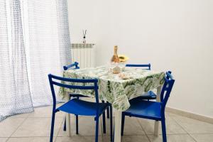 a dining room table with two blue chairs and a table cloth at Palazzo Boemondo in Bari