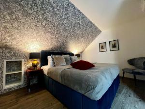Schlafzimmer mit einem Bett mit gemusterter Wand in der Unterkunft Antik Hotel Prague in Prag