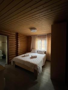 a bedroom with a large bed with a wooden ceiling at Soho Hutor in Bosteri