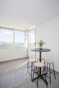 een tafel en stoelen in een kamer met ramen bij Inviting - Douro Vista Apartments in Valbom