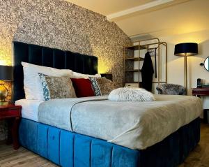 a large bed with a blue headboard in a bedroom at Antik Hotel Prague in Prague