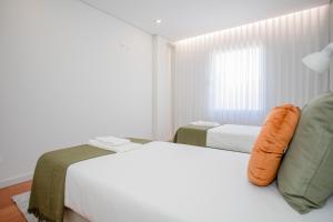 een slaapkamer met 2 bedden en een raam bij Inviting - Douro Vista Apartments in Valbom