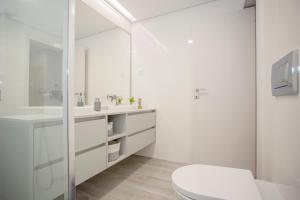 een witte badkamer met een toilet en een wastafel bij Inviting - Douro Vista Apartments in Valbom