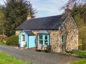 a small stone cottage with a blue door at Heathfield in Denholm