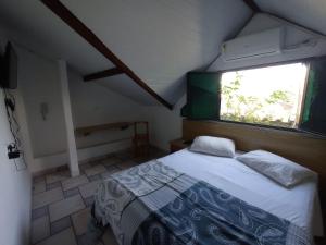 1 dormitorio con cama y ventana en Canto do Casarão, en Santos