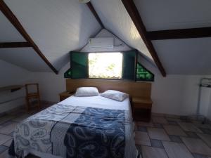 a bedroom with a bed in a attic with a window at Canto do Casarão in Santos