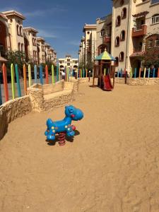 - une aire de jeux avec un chien bleu dans le sable dans l'établissement La sirena, à Ain Sokhna