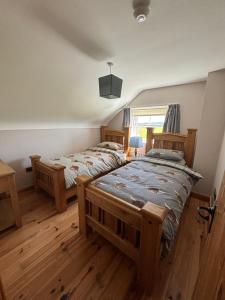 a bedroom with two twin beds and a window at The Old Barn in Fivemiletown