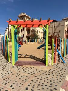a playground with a colorful structure on a beach at La sirena double room with mountain view, Families and couples only, Extra of 180 Egyptian pounds per adult person per stay ,to be paid to the resort in Ain Sokhna