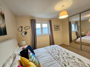 um quarto com uma cama e um espelho grande em Sensational Stay Apartments @ Torwood em Edinburgo