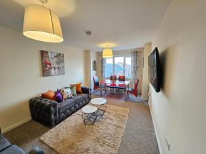 uma sala de estar com um sofá e uma mesa em Sensational Stay Apartments @ Torwood em Edinburgo