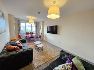uma sala de estar com um sofá e uma mesa em Sensational Stay Apartments @ Torwood em Edinburgo