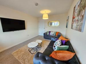 a living room with a couch and a flat screen tv at 2 Bed Apt, 4 beds with Parking in Edinburgh +5 photos